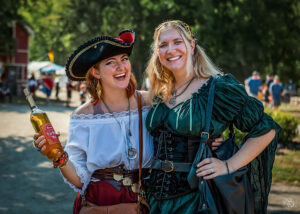 two women in renaissance costume pose with beer