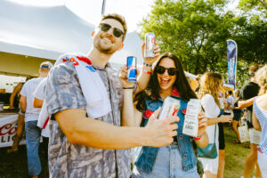 two people at hinterland hold cans of beer